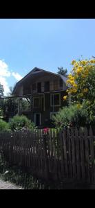 ein Haus mit einem Zaun und Blumen davor in der Unterkunft Green House Nakra in Naki