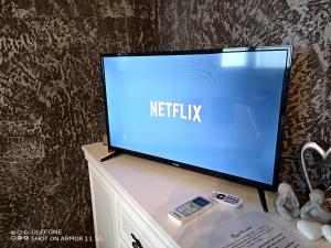 a flat screen tv sitting on top of a dresser at Valeria's Nest in Reşiţa