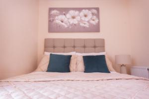 1 dormitorio con 1 cama grande con almohadas azules en Birmingham Apartments Lozells, City Centre en Birmingham