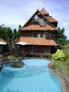 a house with a swimming pool in front of a building at Rumah Tembi in Yogyakarta