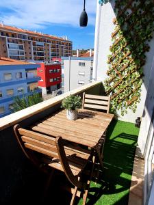 a wooden table and two chairs on a balcony at N3 Apartment in Amadora