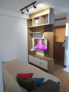 a living room with a tv on a wall at BarraVilha Resort Vista Mar e Pé na Areia in Barra Velha