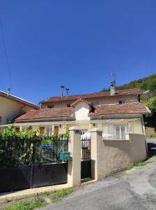 a house with a gate and a fence at Chambres d'hôtes Natacha et Franck in Labastide-Rouairoux