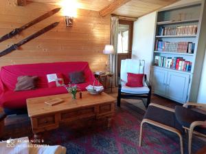 a living room with a red couch and a table at Logis Saint Roch in Saint-François-Longchamp