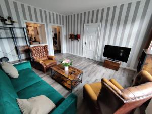 sala de estar con sofá, sillas y TV en Havel Suites, en Havelberg