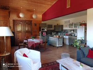 a living room and kitchen with a table and chairs at Logis Saint Roch in Saint-François-Longchamp