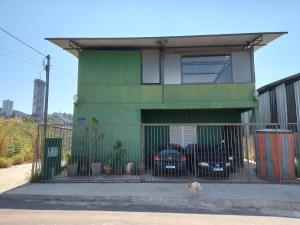 um cão parado em frente a um edifício verde em Pousada Vila da Serra - Quarto Cantinho do Sossego em Nova Lima