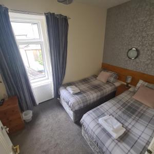 a room with two beds and a window at Glenmoore Guest House in Oban