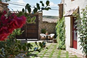 eine Terrasse mit Tisch und Stühlen in einem Hof in der Unterkunft La Casa del Azafrán in Villanueva del Rebollar de la Sierra