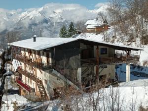 a house in the snow with mountains in the background at Logis Saint Roch in Saint-François-Longchamp