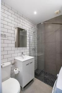 La salle de bains est pourvue de toilettes, d'un lavabo et d'une douche. dans l'établissement Estudio W&G Las Canteras con bonitas vistas al mar, à Las Palmas de Gran Canaria