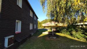 a backyard with a covered table and a house at Penzion U Rybníka in Mariánská