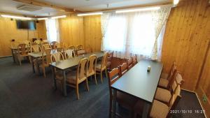 einen Konferenzraum mit Tischen, Stühlen und einem Fenster in der Unterkunft Penzion U Rybníka in Mariánská
