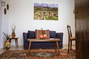 a living room with a blue couch and a table at MY HOME in Áno Lekhónia