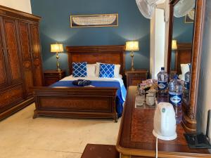 um quarto com uma cama com paredes azuis e uma mesa em Santa Marija House em Victoria