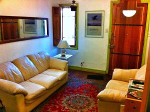 a living room with a leather couch and a window at Tralkan B&B in Santiago