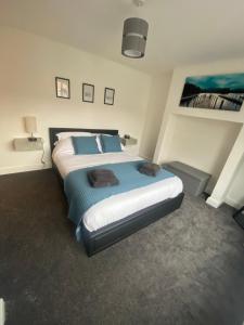 ein Schlafzimmer mit einem großen Bett mit blauen Kissen in der Unterkunft Lovely 1-bedroom apartment with garden and parking in Stone
