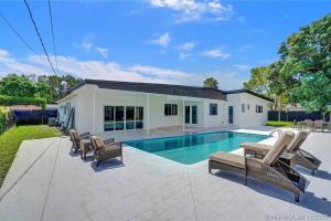 ein Swimmingpool mit Stühlen und ein Haus in der Unterkunft Pool Villa in Miami