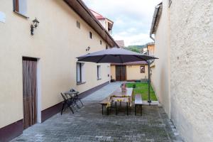 a patio with a table and an umbrella at Mario's Cozy Apartment in Râşnov
