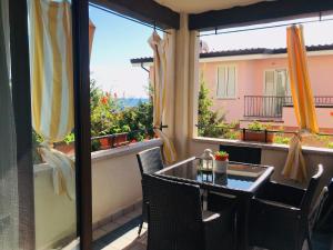 een balkon met een tafel en stoelen en een raam bij Brezza marina in Santa Maria Navarrese