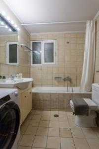 uma casa de banho com uma banheira, um WC e um lavatório. em NiMa's Beach Apartment em Chania