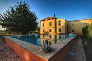 a house with a swimming pool in front of a house at Casa Rural Finca Juanamare in Yecla