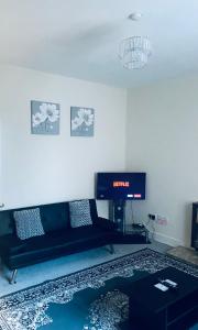 uma sala de estar com um sofá e uma televisão em Largs Holiday Apartment em Largs