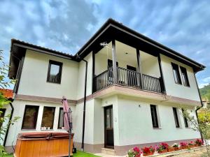a white house with a balcony at Kassandrova Guest House & Spa in Bratsigovo