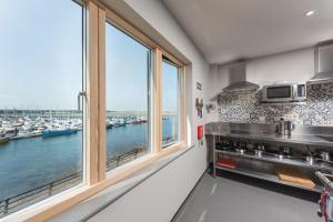een keuken met een groot raam met uitzicht op een jachthaven bij Radcliffes Lodge in Amble