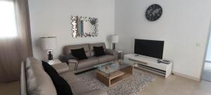 salon z kanapą i telewizorem w obiekcie Villa Cástor w mieście Playa Blanca