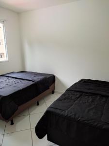 a bedroom with two beds and a window at Temporada balneário camboriu in Balneário Camboriú