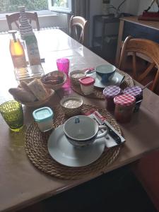 einen Tisch mit Teller und Schüsseln mit Essen drauf in der Unterkunft Suite familiale Mamito et Papito in Notre-Dame-du-Bec