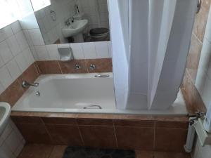 a bathroom with a bath tub and a sink at TM Self Catering Accommodation in Middelburg
