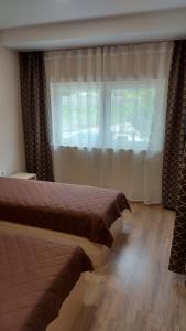 a bedroom with two beds and a window at Forest Apartment in Sapareva Banya