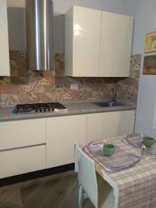una cucina con armadi bianchi, lavandino e tavolo di Tom & Jerry a Pisa