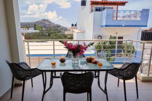 een tafel met een vaas met bloemen op een balkon bij Mirtos Luxury apartment in Myrtos