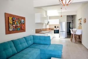 een woonkamer met een blauwe bank en een keuken bij Mirtos Luxury apartment in Myrtos