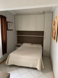 a bedroom with a bed and white cabinets at Cobertura frente ao mar Meia Praia -Itapema -SC in Itapema