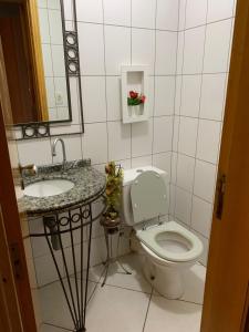 a bathroom with a toilet and a sink and a mirror at Cobertura frente ao mar Meia Praia -Itapema -SC in Itapema +21 photos