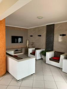 a living room with white furniture and a flat screen tv at Cobertura frente ao mar Meia Praia -Itapema -SC in Itapema