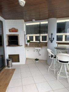 a kitchen with a table and chairs and a sink at Cobertura frente ao mar Meia Praia -Itapema -SC in Itapema