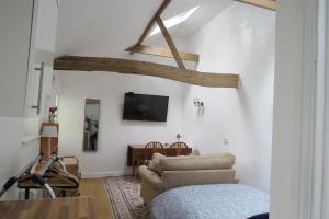 a living room with a couch and a tv on the wall at The Old Stables, Whitehall Farmhouse, Oakington in Cambridge