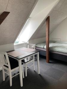 a room with a desk and a bed and a table and chairs at Varde Bed and Kitchen in Varde