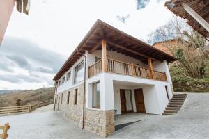 Casa blanca con balcón en la parte superior. en Apartamentos tiu Enrique 1 en Cangas de Onís