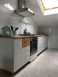 a kitchen with white cabinets and a stove top oven at Casa vicino al mare in Rimini