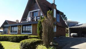 a house with a tree in front of it at Chalé Lady in Campos do Jordão
