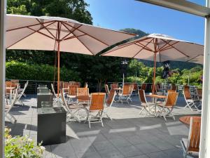 a patio with tables and chairs and umbrellas at Haus des Sports in Bad Kreuznach