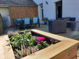a wooden deck with a garden with purple flowers at La casa pétillante ! in Ay