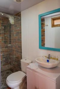 a bathroom with a toilet and a sink and a mirror at hotel villa claudia in Nobsa