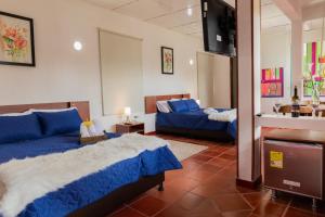 a bedroom with a bed and a couch and a television at hotel villa claudia in Nobsa